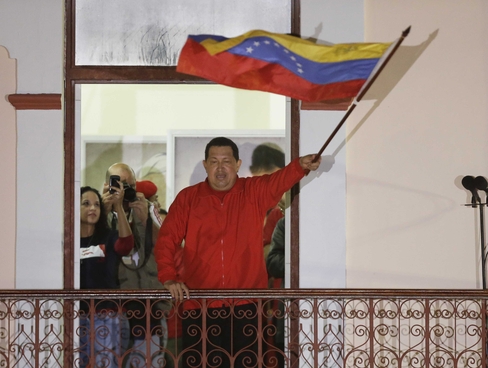 Chavez waves flag to supporters. Photo Courtesy Fernando Llano, AP
