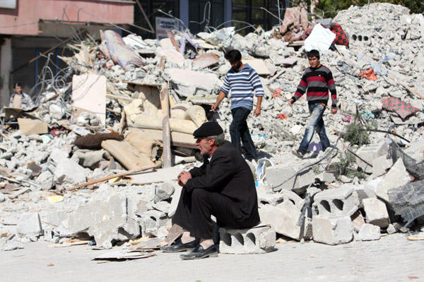People survey the damage after an earthquake in Turkey left at least 432 people dead.  (AP)