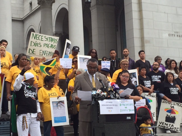 Council Member Curren Price stands with supporters on the steps of City Hall. 