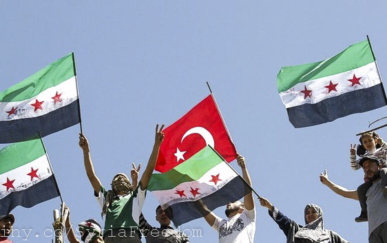 Syrian refugees wave Turkish and Syrian Independence Flags at a protest against Assad in April 2012. (Freedom House)