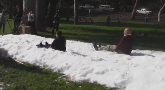 Councilman Ed Reyes slides down a snow hill (Kayla Colin/ATVN)